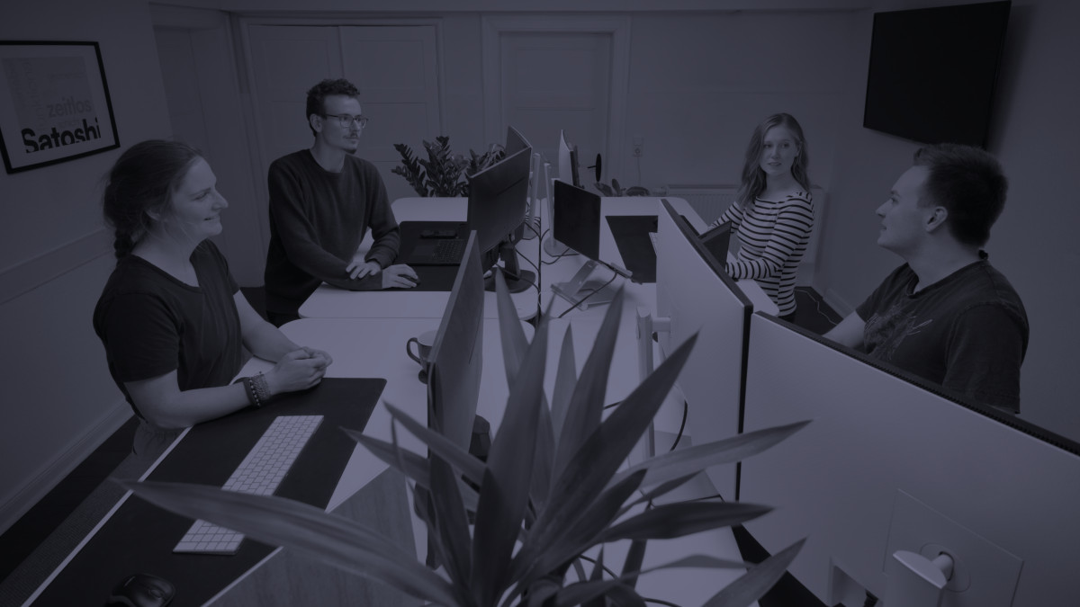 Menschen diskutieren in einem Großraumbüro.